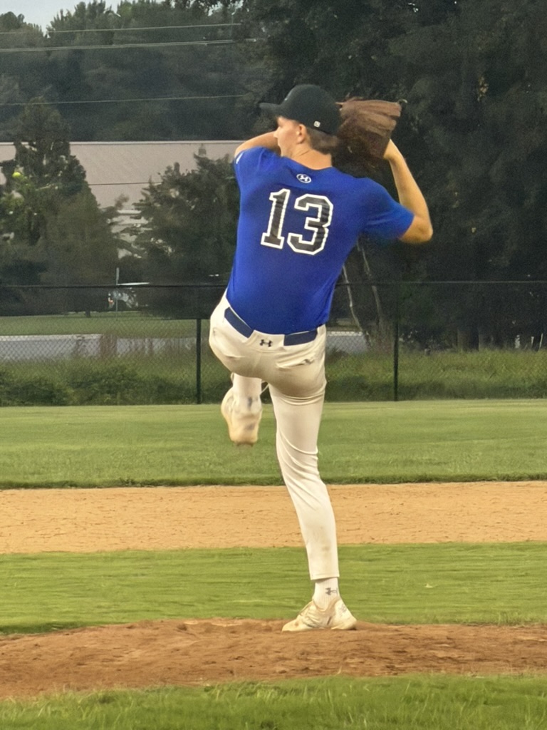 Brayden Kiernan in his pitching windup wearing his blue number 13 API Academy uniform